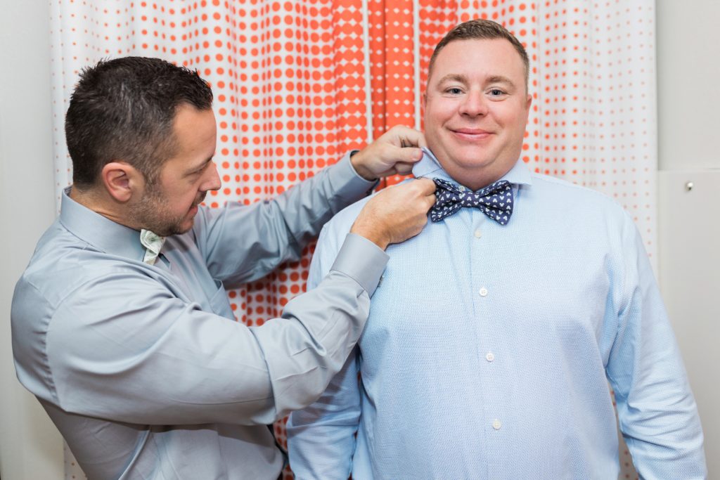 Groomsman and groom at Disney wedding fixing tie