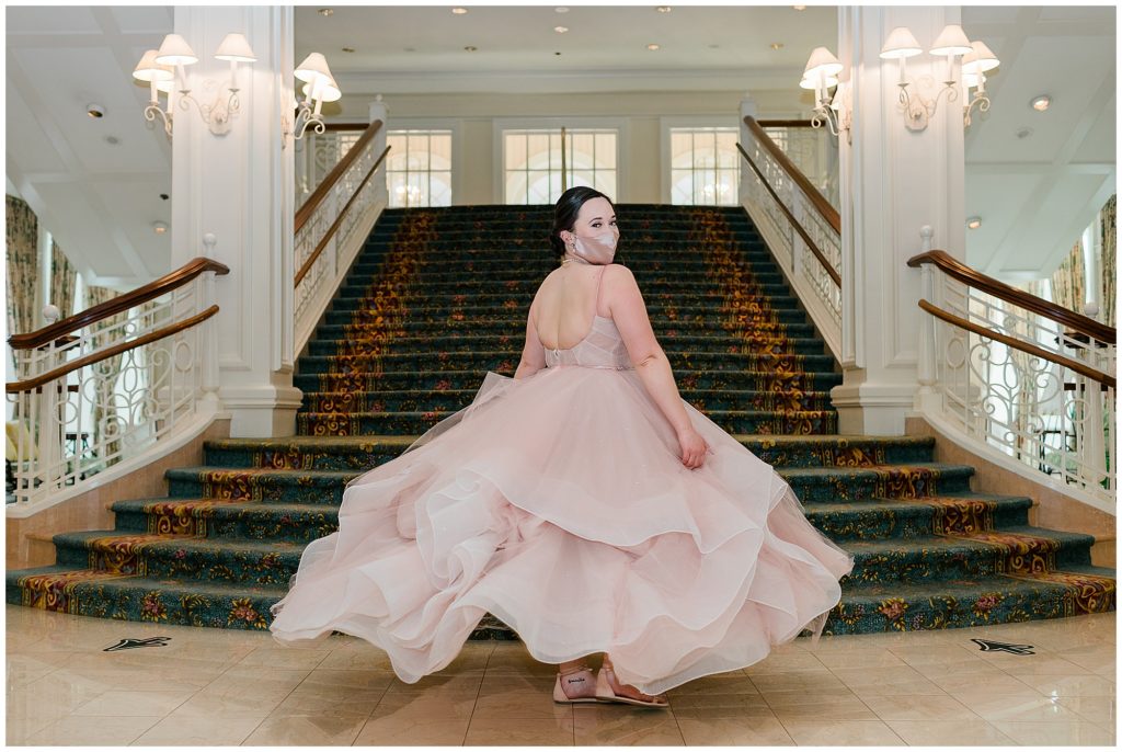 bride twirling in her wedding gown on staircase