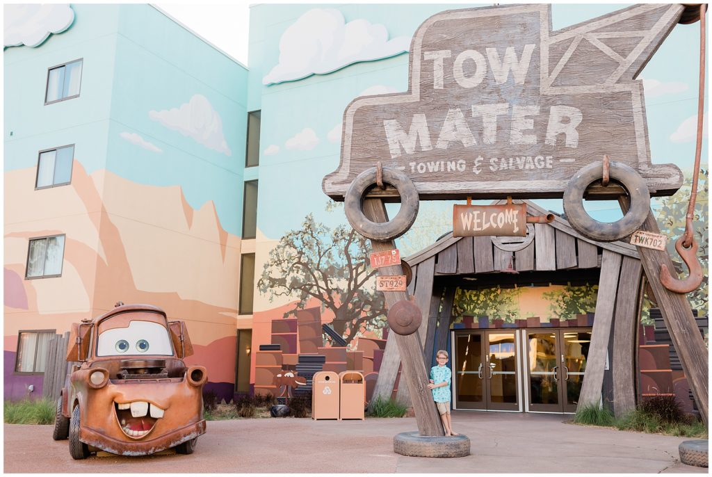 Tow Mater sign and car with boy standing under the sign