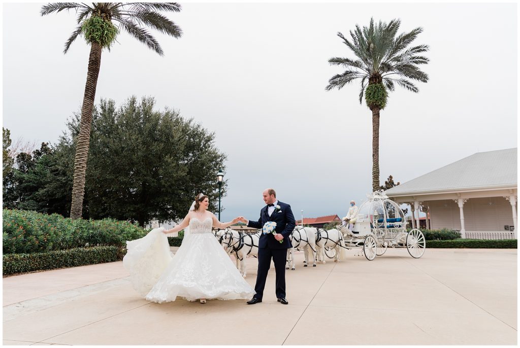 wedding couple in front of Cinderella's Coach and Disney's Wedding Pavilion