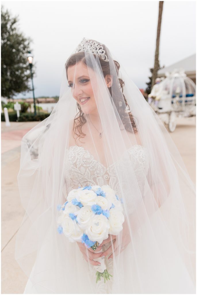 bride under veil during disney wedding smiling